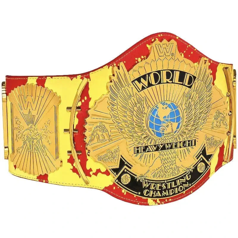 Angled view of a Hulk Hogan championship belt with gold eagle plates, blue globe and red-yellow strap.