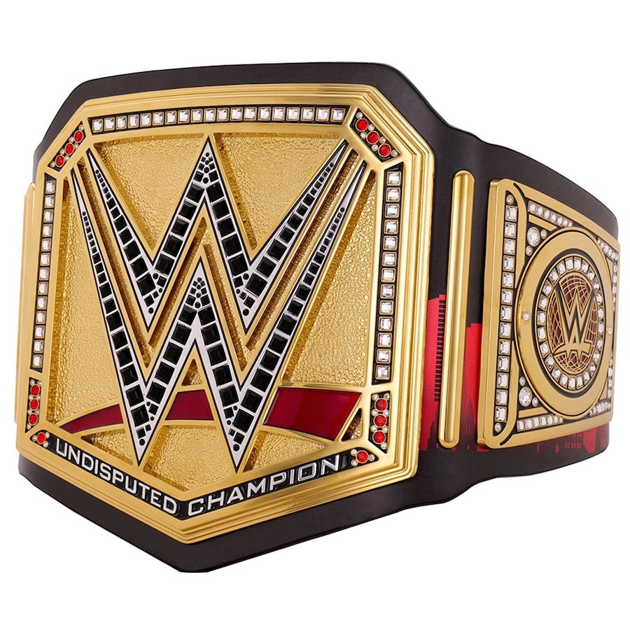 Angled view of a modern gold Undisputed Championship wrestling title with red accents and jeweled center logo.