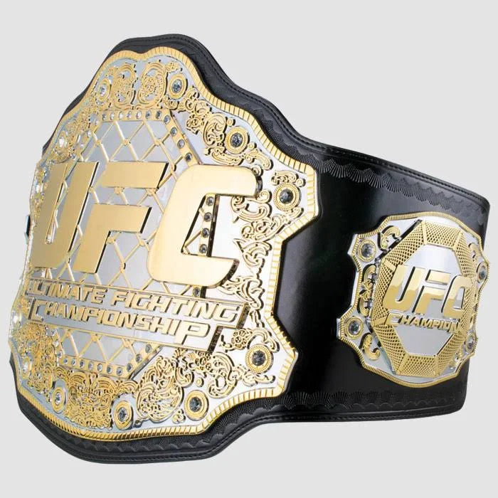 Angled view of a gold UFC championship belt with black leather strap and detailed side plate.